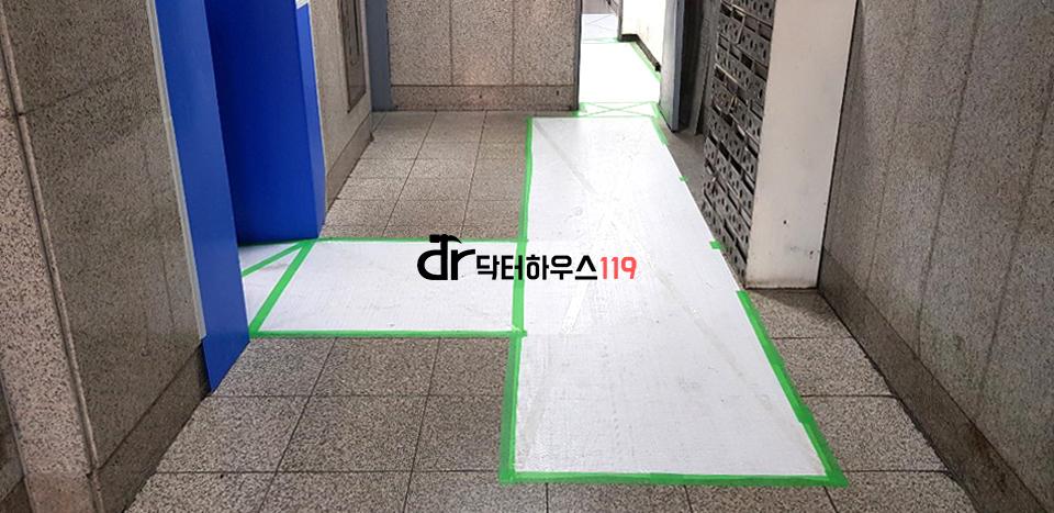 파란색 문과 벽돌 벽이 보이는 복도 공간