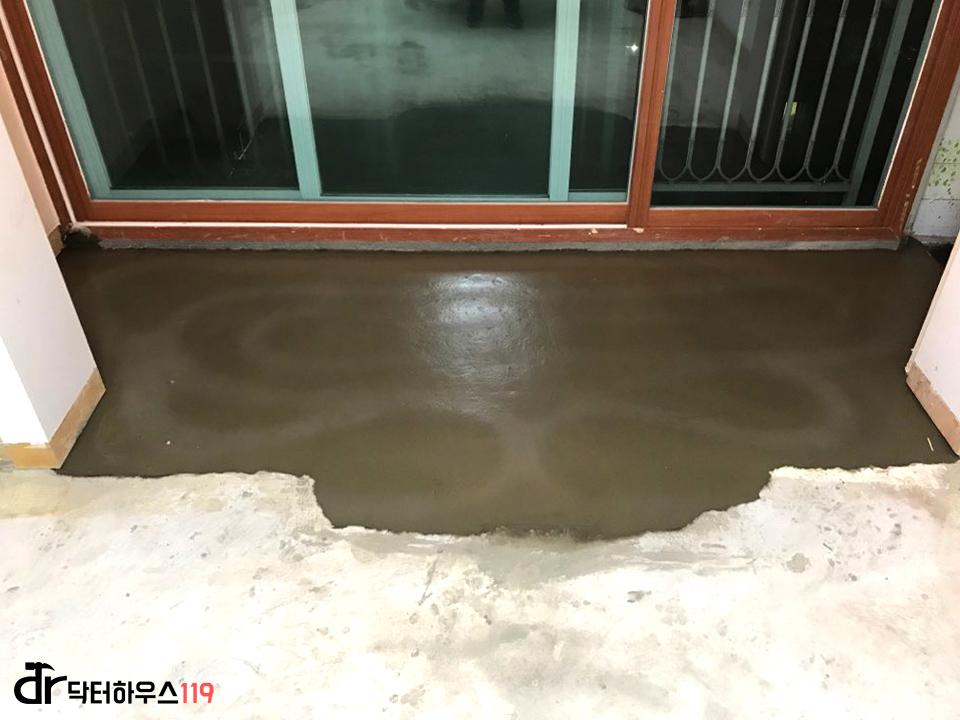 흰 벽돌과 갈색 바닥재가 보이는 현관 측면
