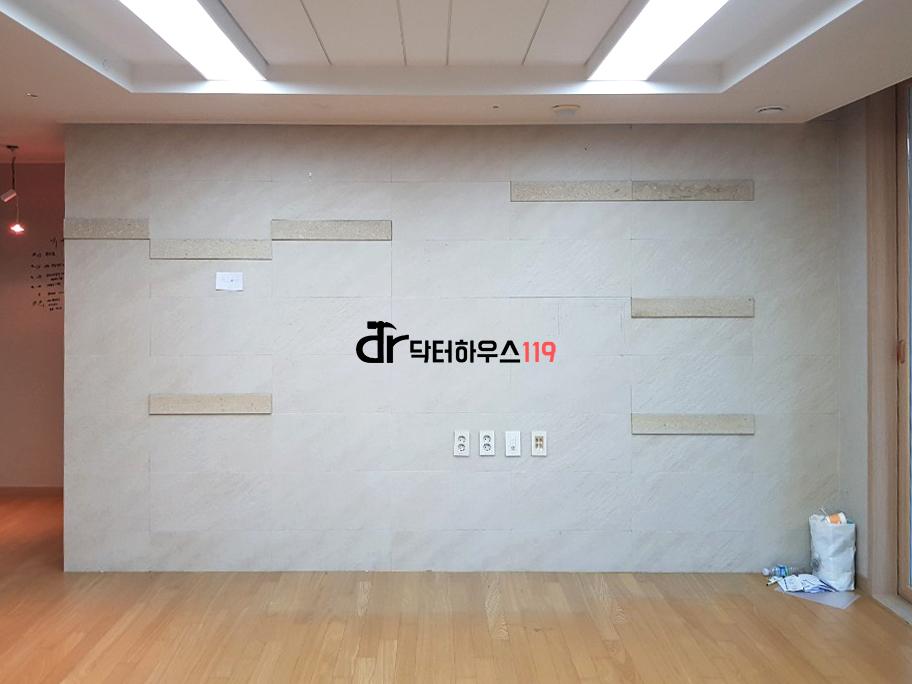 차분한 회색 벽돌 질감의 벽면과 목재 바닥