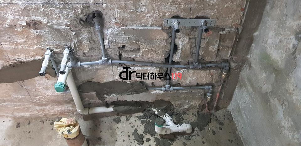 벽면에 노출된 금속 및 플라스틱 파이프 배관