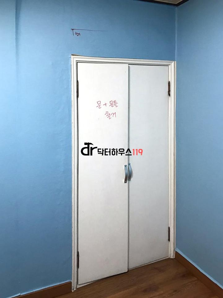 파란 벽과 나무 바닥에 설치된 흰색 슬라이딩 도어