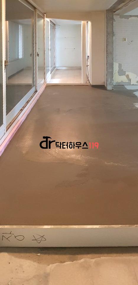 콘크리트 바닥과 벽면 일부가 노출된 빈 복도