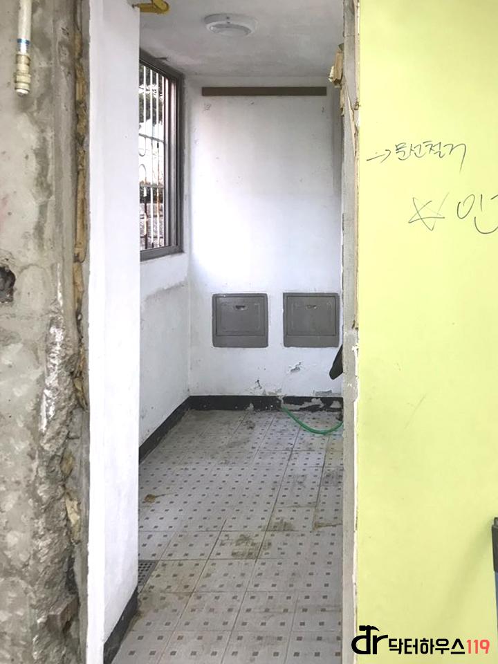 흰색 타일이 깔린 복도와 금속 박스 설치 모습
