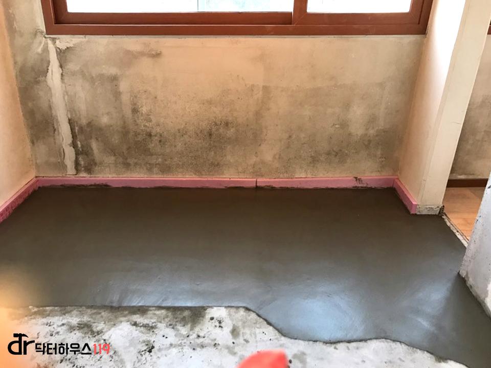 핑크색 하단 마감과 회색 콘크리트 바닥의 공간