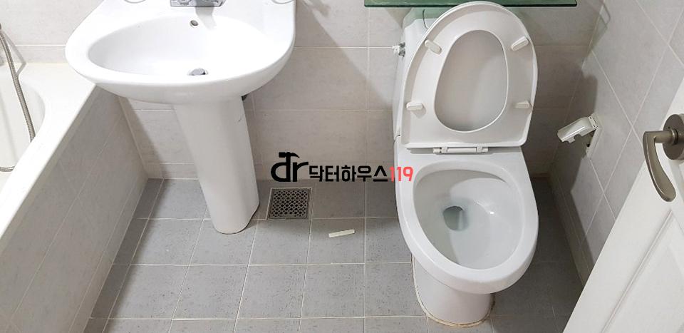 화이트 톤 도자기 변기와 세면대가 설치된 욕실