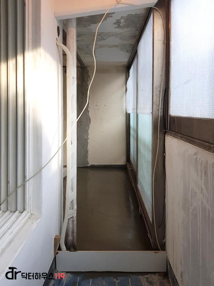 노출된 천장과 흰색 관이 보이는 복도
