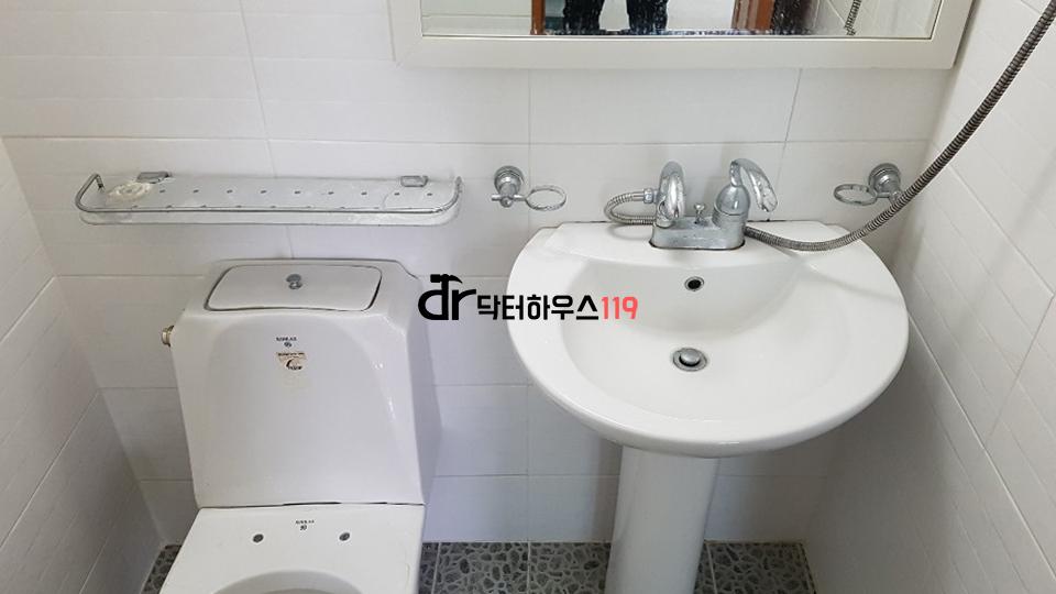 흰색 타일로 정돈된 화장실 내부