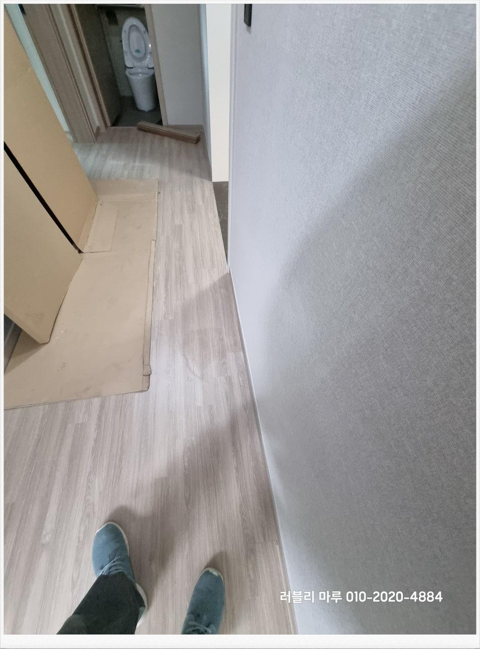 회색 텍스처 벽지와 목재 패턴 바닥재의 마감