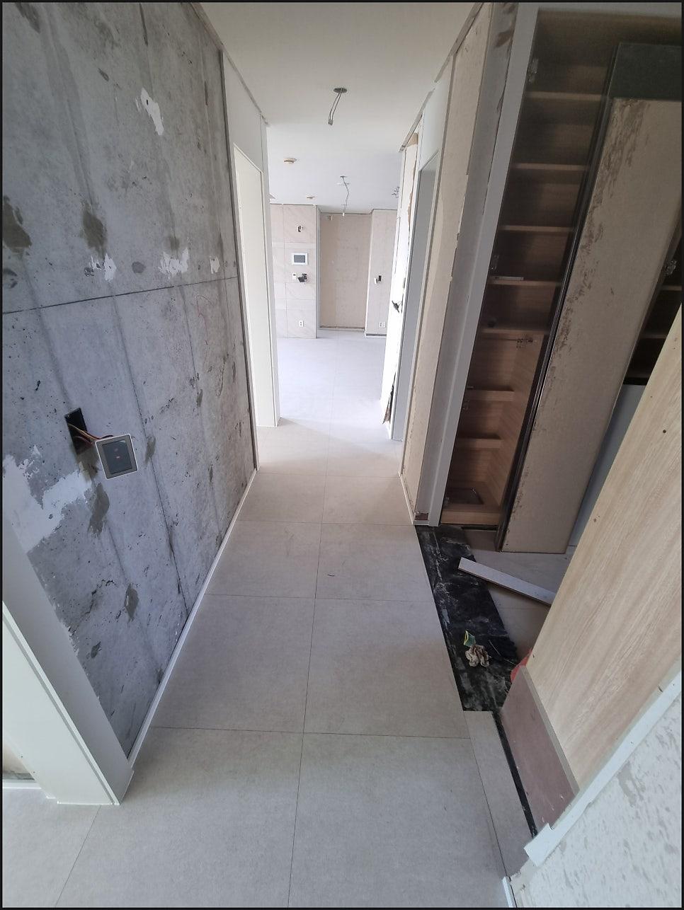 수납장 내부가 노출된 복도의 콘크리트 벽면
