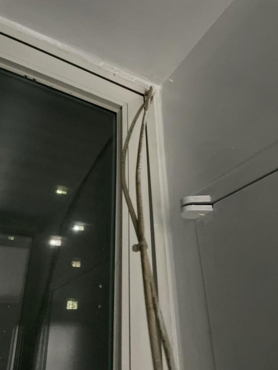 창호 프레임과 벽면 사이에 고정된 케이블