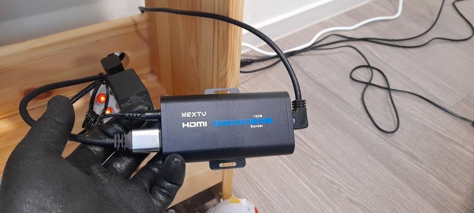 검은 고무장갑으로 잡고 있는 HDMI 확장기와 전선들