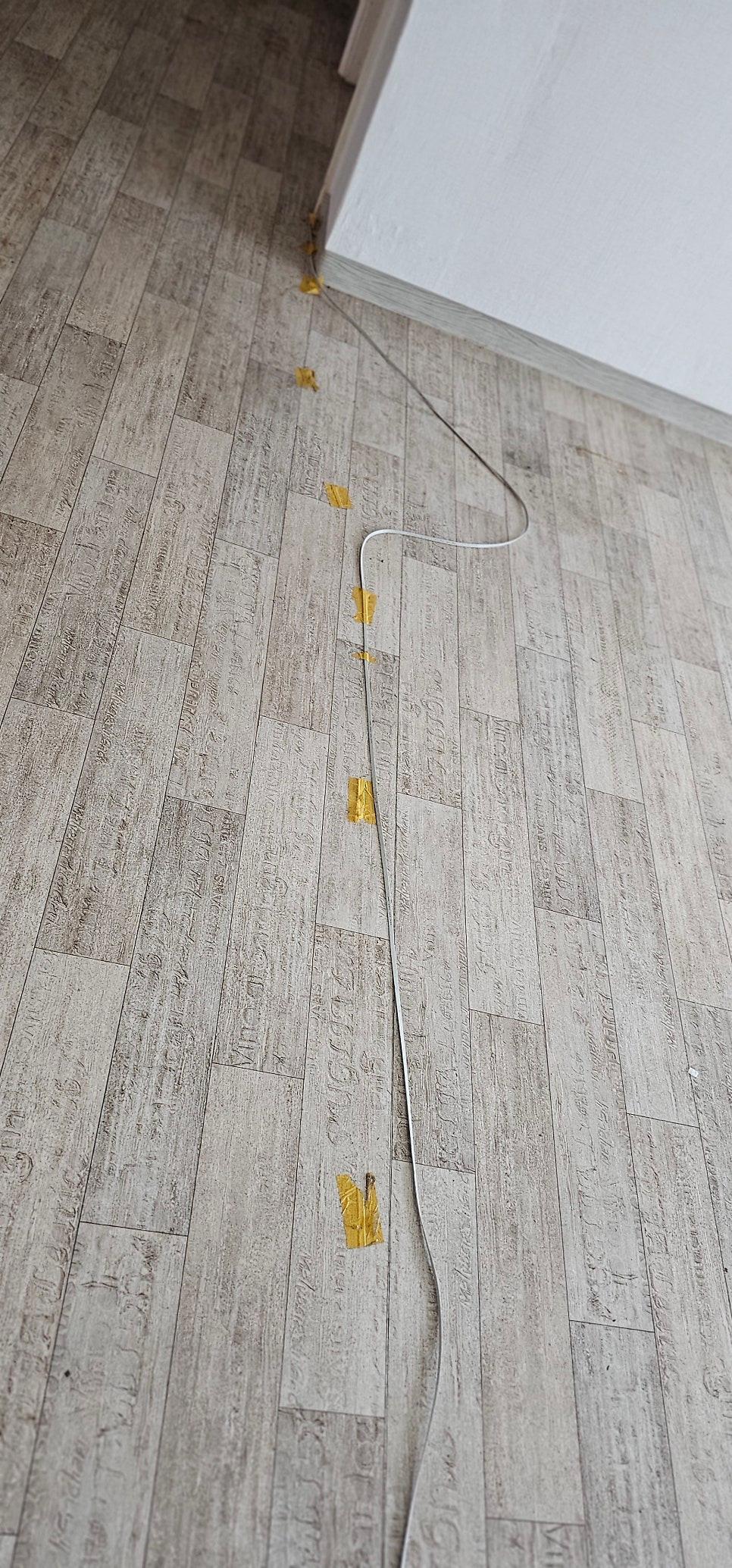 바닥재 위에 고정된 흰색 전선