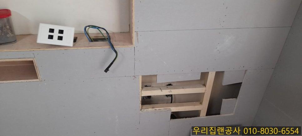 회색 벽면의 스위치 설치 과정과 나무 구조물