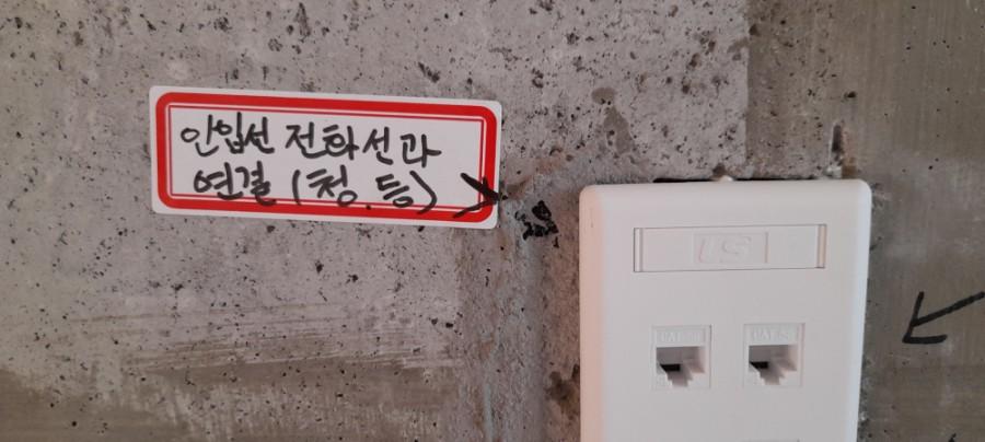 빨간 테두리 스티커가 붙은 흰색 전화 콘센트