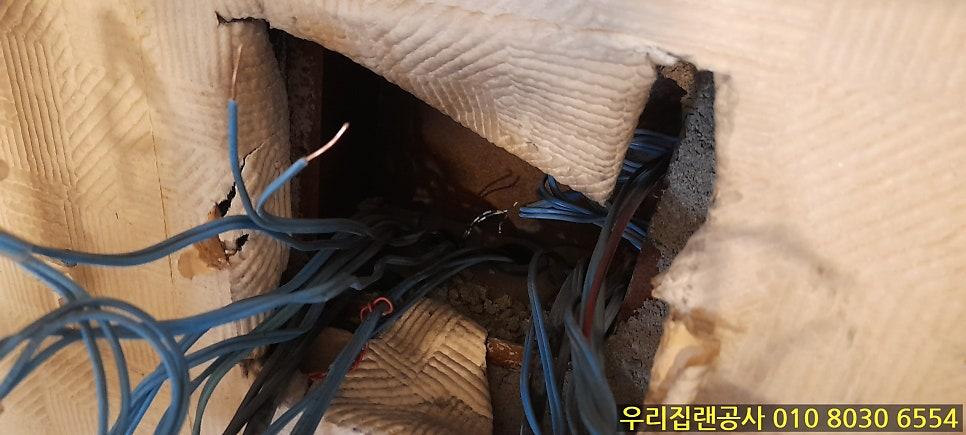 목재 구조물 속 노출된 파란색 전선과 절단된 선들