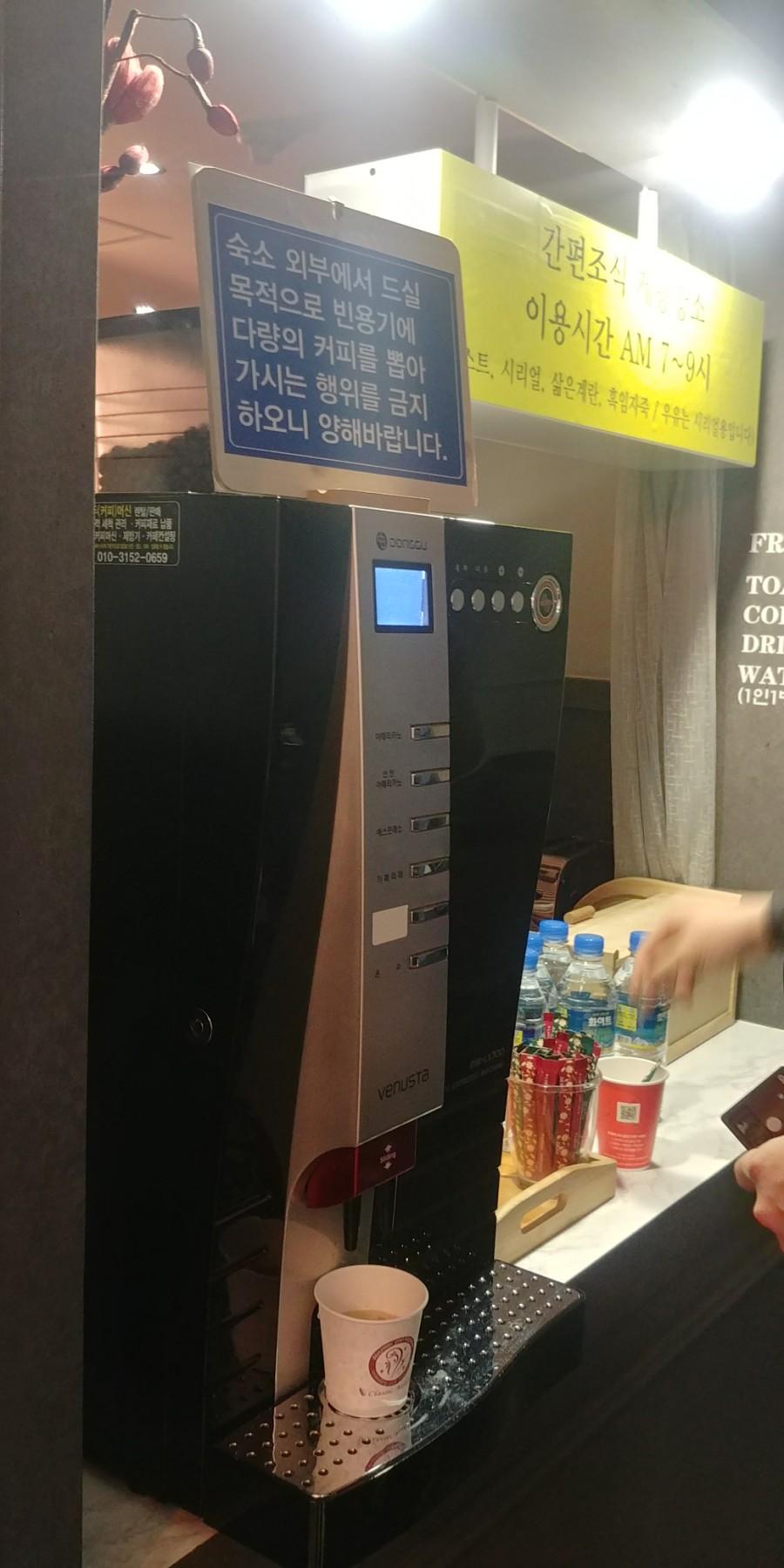 안내문이 부착된 커피머신과 셀프 바 공간