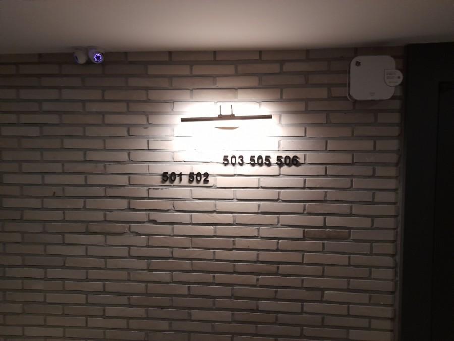 벽등과 방 번호판이 설치된 벽면