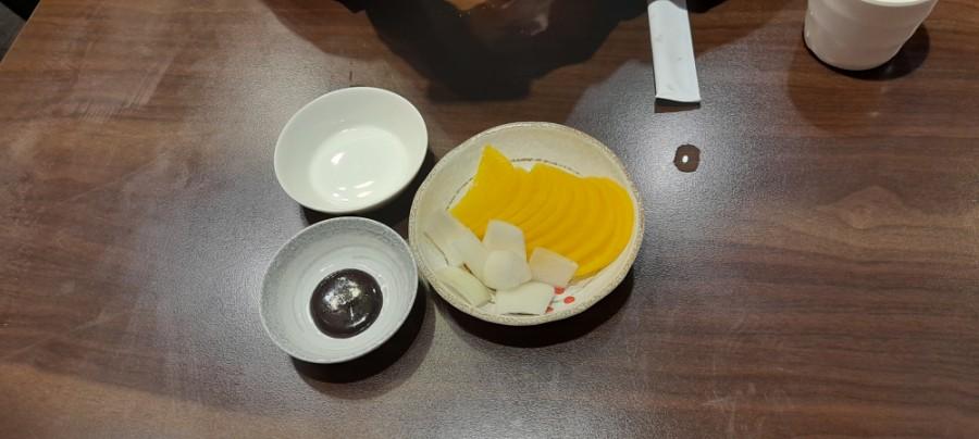 나무 테이블 위에 놓인 흰색과 베이지색 그릇들