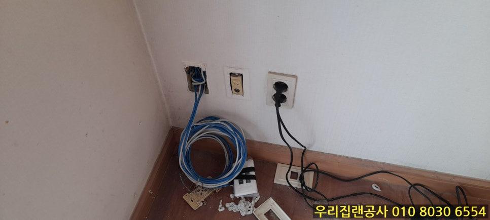 흰 벽에 노출된 전선과 소켓, 바닥의 케이블들