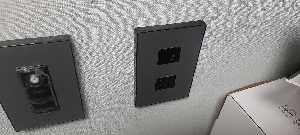 검은색 벽면에 설치된 스위치 및 케이블 커넥터