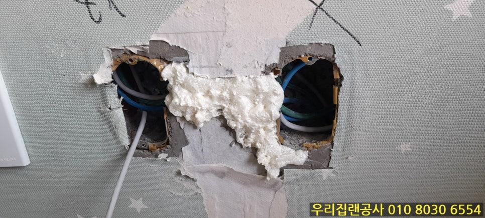 벽 구멍 사이로 노출된 전선과 거품 제재물