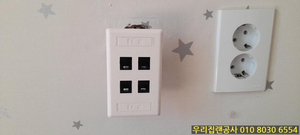 흰색 별무늬 벽면에 설치된 전기 소켓과 RJ45 포트