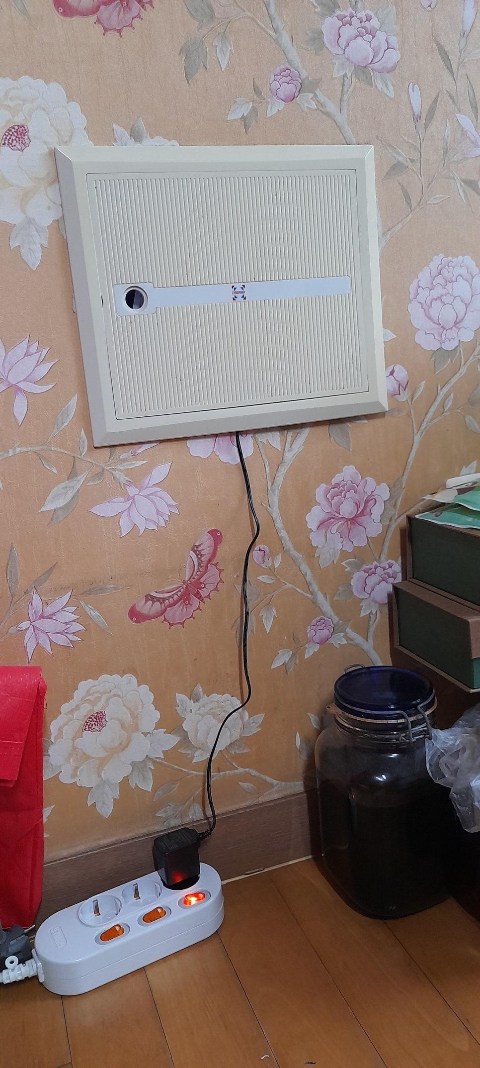 벽면에 부착된 장치와 바닥의 전원 어댑터 모습