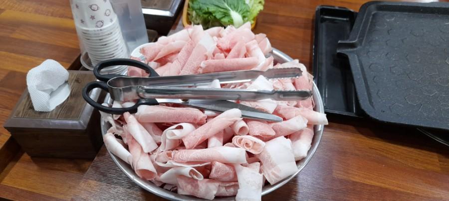 돼지 등심과 조리 도구가 놓인 주방 테이블