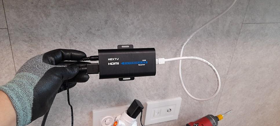 검은색 HDMI 확장기와 흰색 케이블의 연결 상태