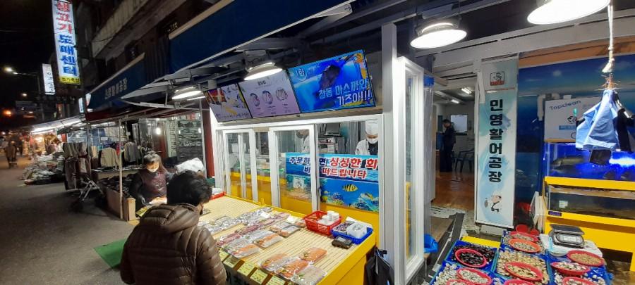 밝은 조명 아래 상품들이 진열된 야간 수산물 시장