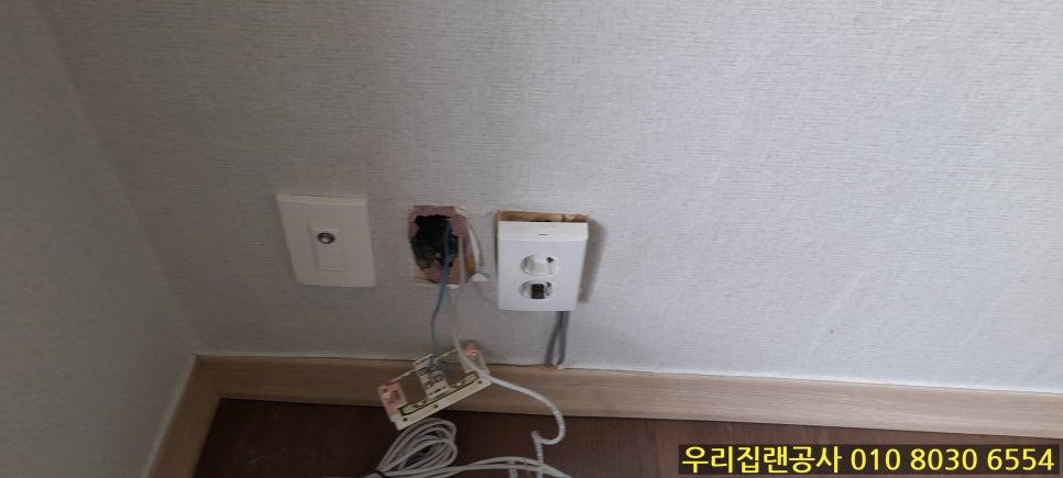 전선이 노출된 흰색 벽면의 스위치와 소켓