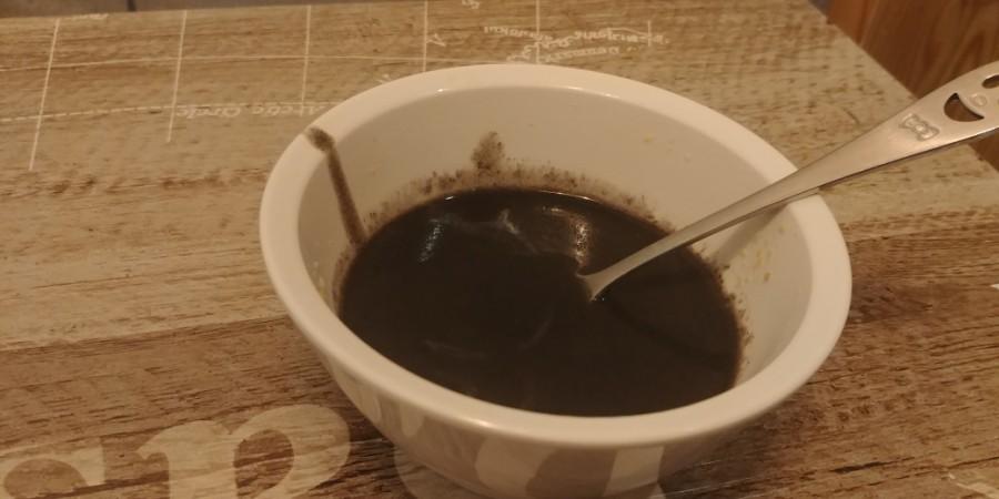 흰색 그릇에 담긴 검은색 액체와 스푼