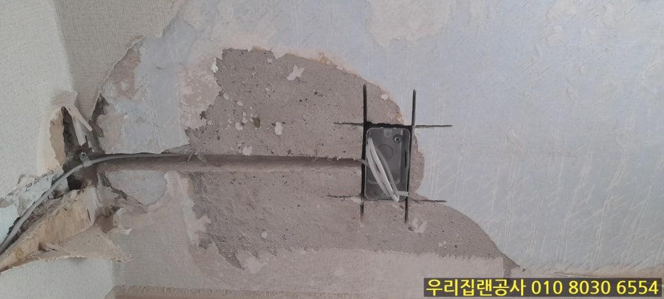 콘크리트 벽면에 노출된 전선과 금속 지지대