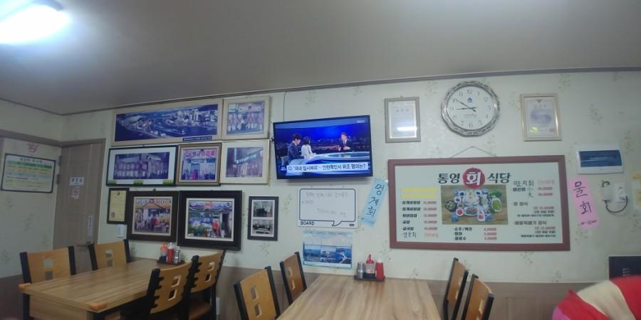 메뉴판과 TV, 사진 프레임이 걸린 식당 내부