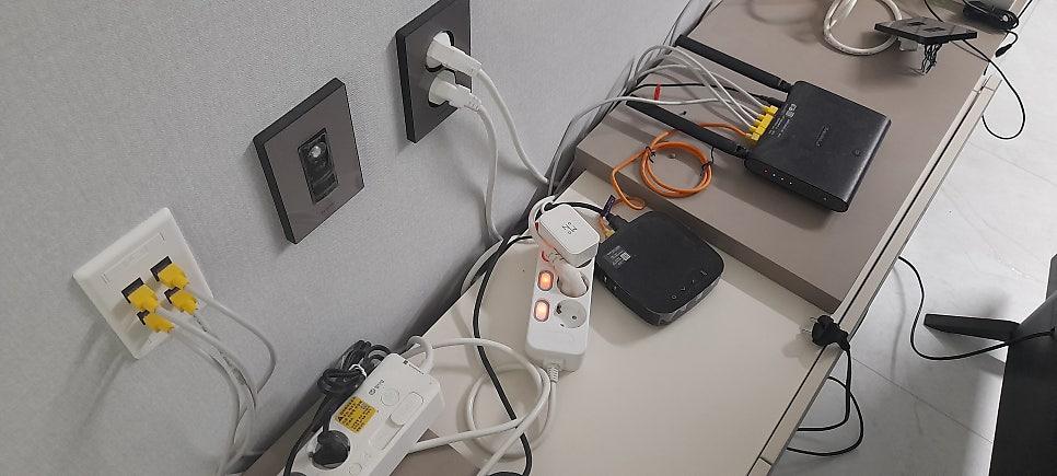 벽면 스위치와 여러 전자 기기 및 케이블 연결 상태