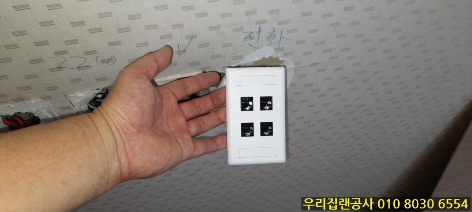 흰색 벽지와 손에 든 흰색 전기 스위치 패널