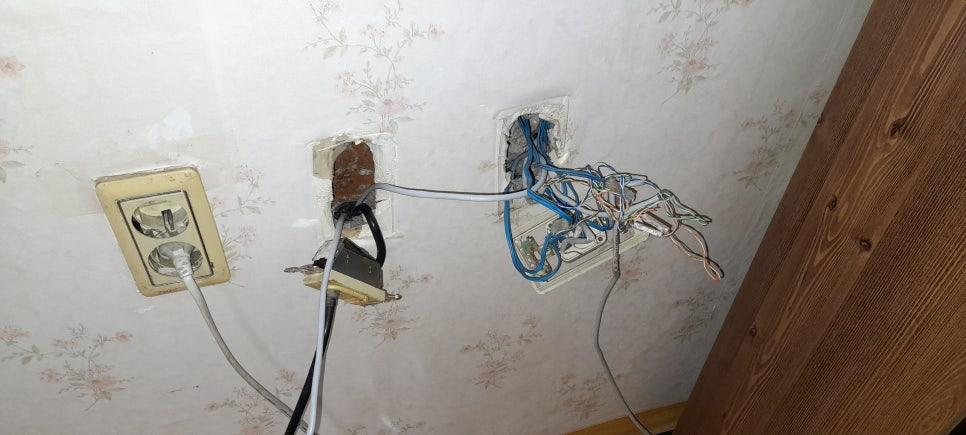 꽃무늬 벽지와 노출된 전기 소켓