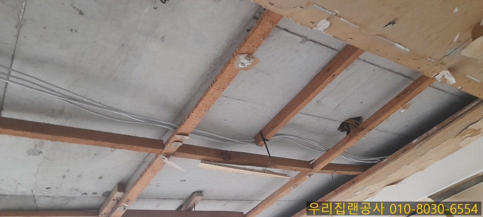 나무 보와 전선이 노출된 콘크리트 천장 내부