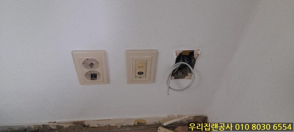 흰 벽의 전기 소켓과 스위치 및 전선 구멍