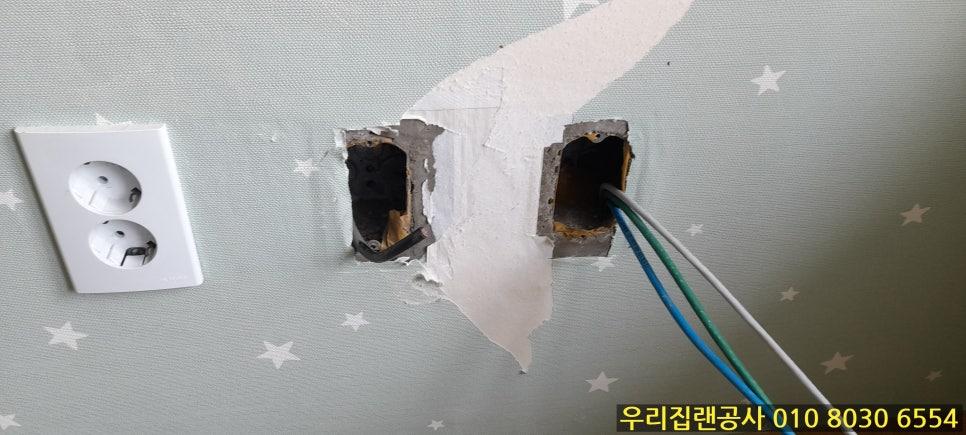 전기 소켓 옆으로 배선 작업 중인 벽면 구멍
