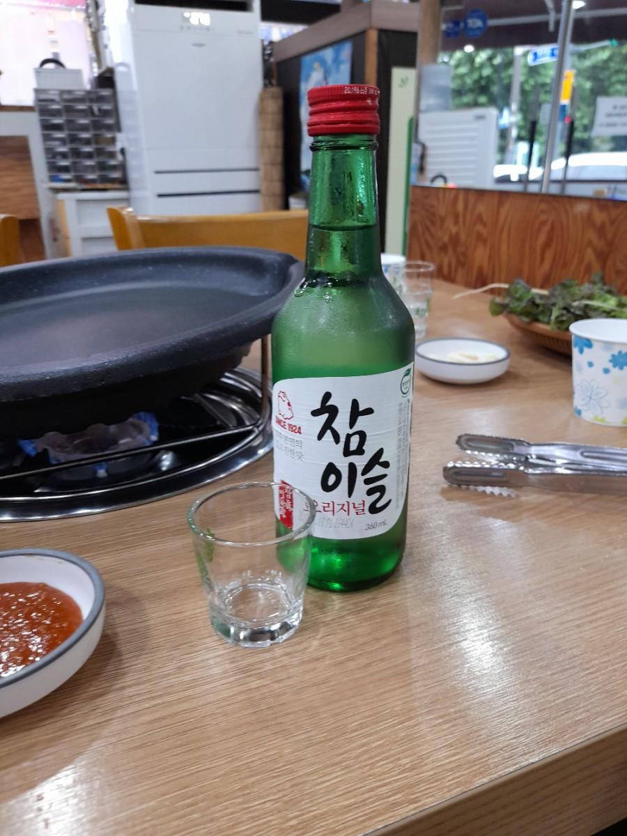 녹색 병의 술과 냄비가 놓인 식사 자리