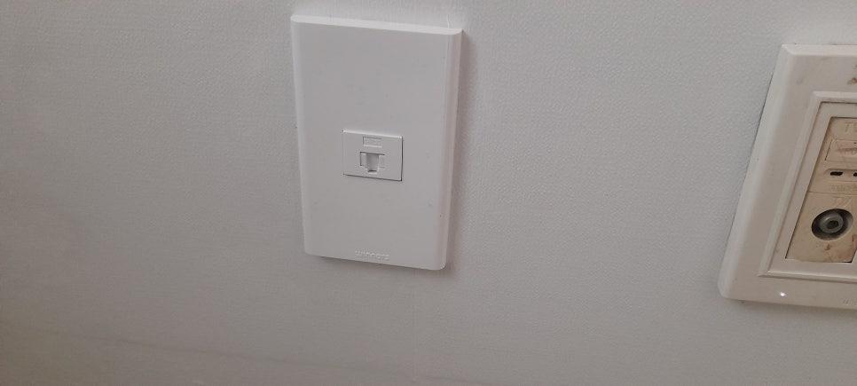 흰 벽에 설치된 흰색 전화선 커넥터와 장치