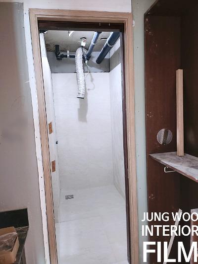 배관이 노출된 천장과 흰색 타일 마감 공간