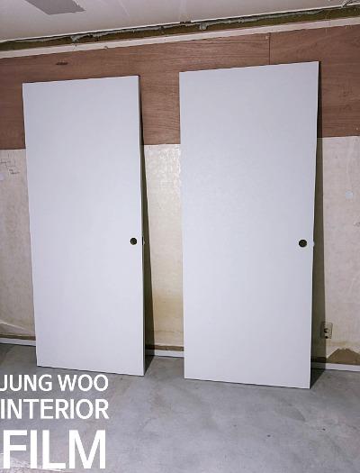 벽에 세워진 필름 마감 도어와 베이지색 벽지
