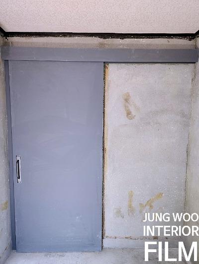 회색 슬라이딩 도어와 노란 흔적이 있는 벽면