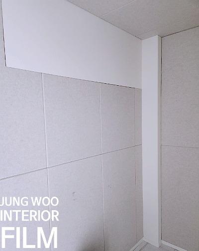 흰색 벽면과 천장, 벽면 타일이 보이는 실내 모습