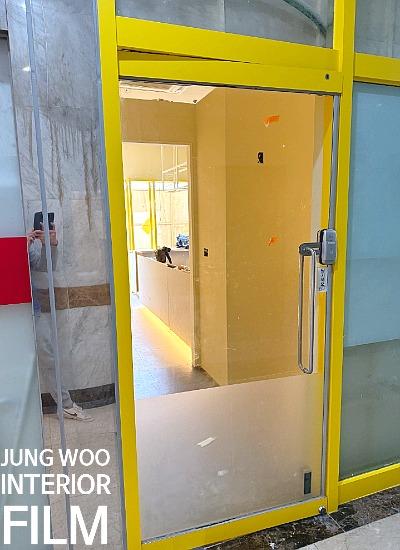 노란색 프레임의 유리문과 내부 복도