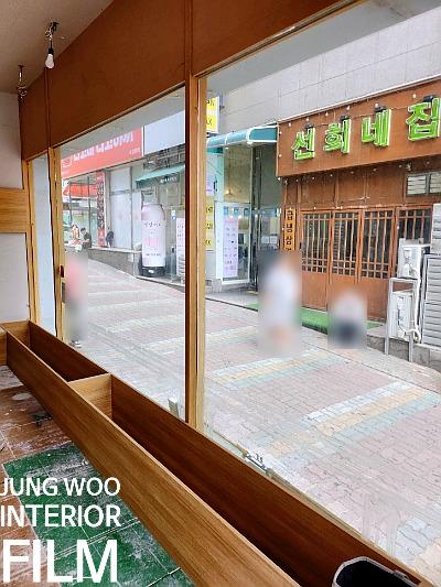 나무 재질 장식 베이스가 설치된 창가와 외부 간판 풍경