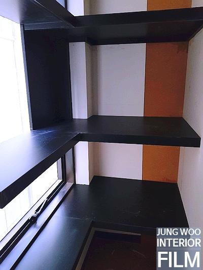 검은색 상판과 주황색 벽면이 대비되는 창가