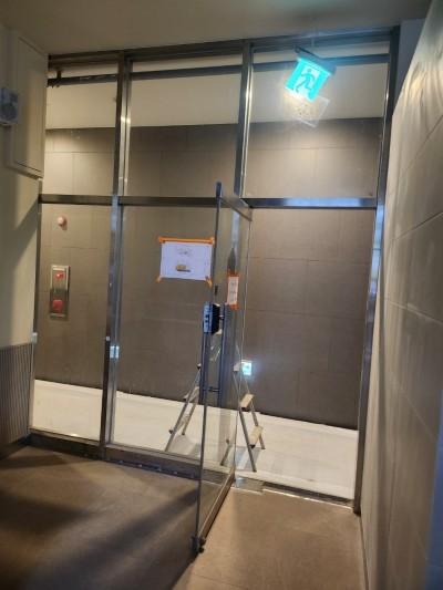 베이지색 타일 벽면과 유리문이 설치된 복도